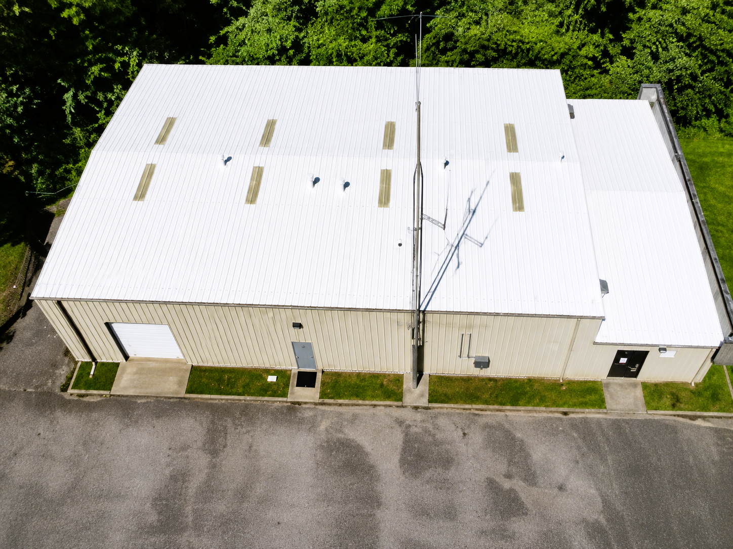 After: the same commercial metal roof in Bloomington, Indiana restored with a bright white Conklin reflective coating system
