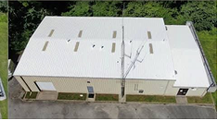 After: the same warehouse roof restored with a white Conklin reflective coating system