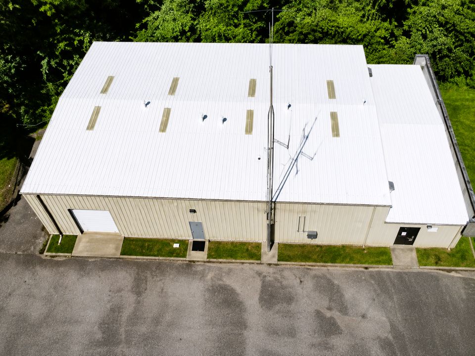 The same Bloomington, Indiana metal roof after a Conklin white reflective metal roof coating system was installed