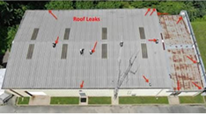 Before: aerial view of a gray metal warehouse roof with roof leaks marked across the panels