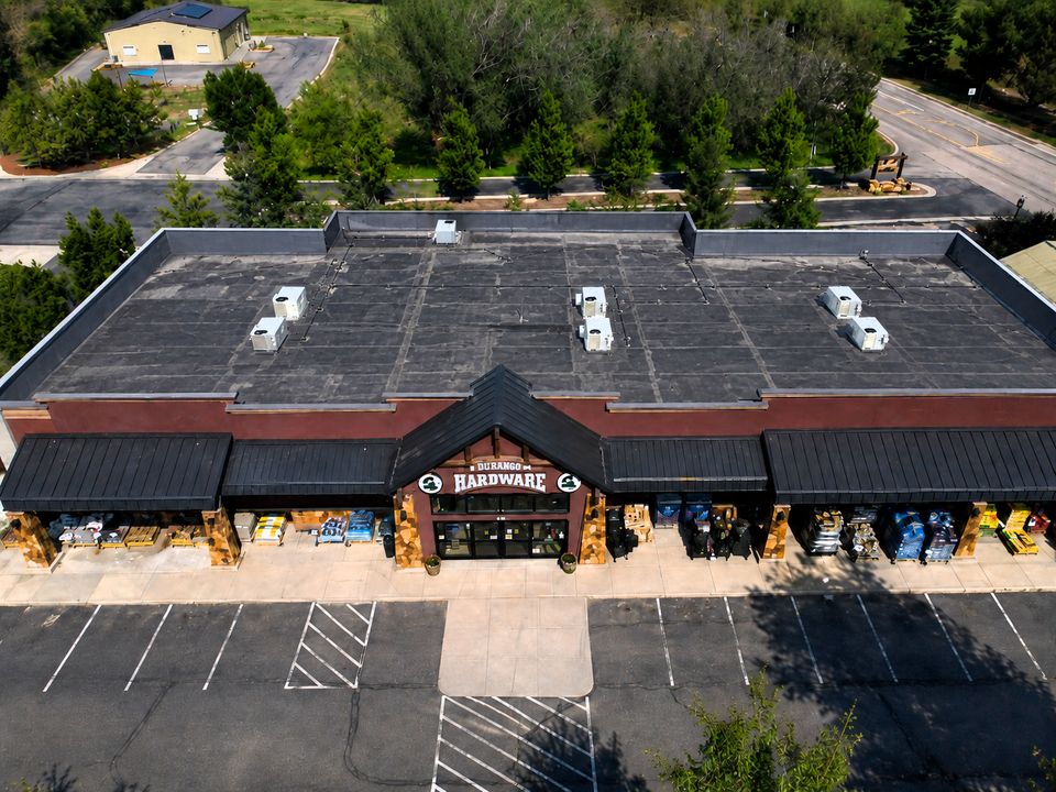 Flat commercial roof with weathered surface and poor drainage before a silicone roof coating system